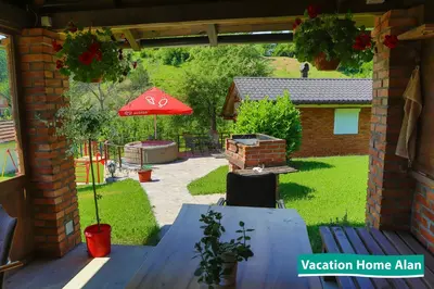a patio with a table and a red umbrella at Vacation home Alan 2 in Kulen Vakuf