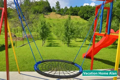 a swing in a park with a green field at Vacation home Alan 2 in Kulen Vakuf