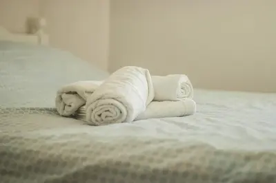 a pile of towels sitting on top of a bed at Apartments Bašić in Visoko