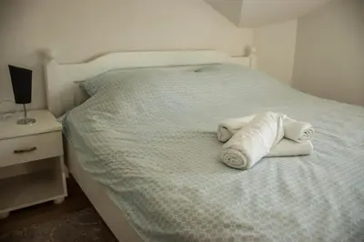 a bed with two rolled towels on it at Apartments Bašić in Visoko