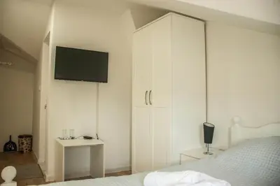 a bedroom with a white cabinet with a television on it at Apartments Bašić in Visoko