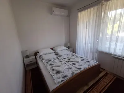 a bedroom with a bed and a window at Apartman Banja - Tuzla in Tuzla