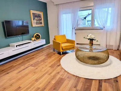 a living room with a coffee table and a yellow chair at Apartmani Jasmina 2 in Bihać