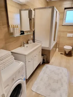 a bathroom with a washing machine and a sink at Apartmani Jasmina 2 in Bihać