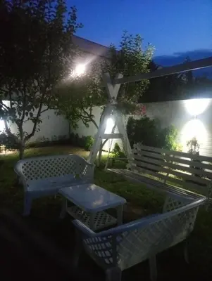 a picnic table and a bench in a yard at night at Apartmani Jasmina 2 in Bihać
