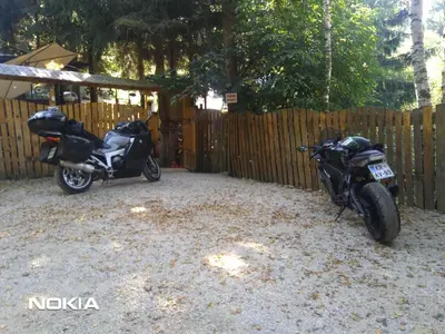 two motorcycles parked next to a wooden fence at Holiday Home Nature Neno in Visoko