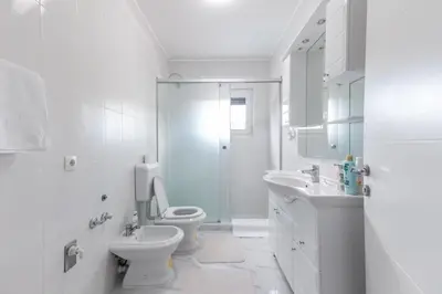 a white bathroom with a toilet and a sink at Holiday Home Ajna in Bihać