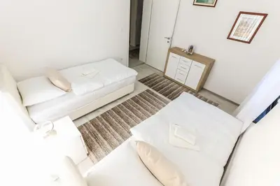 a white living room with a couch and a table at Holiday Home Ajna in Bihać