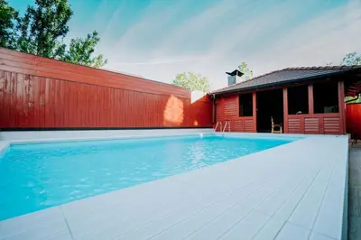 a swimming pool in front of a red building at Holiday Home Ajna in Bihać