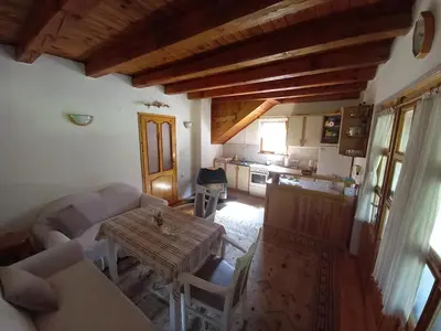 a living room with a table and a kitchen at Holiday home 
