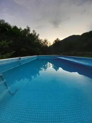 a pool of blue water with trees in the background at Holiday home 