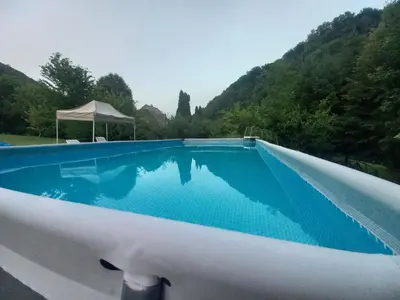 a swimming pool with blue water in front of a mountain at Holiday home 