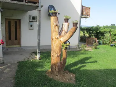 a tree stump with two potted plants on top of it at Country House Roman in Doboj