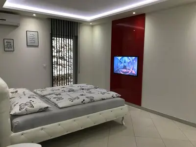 a bedroom with a bed and a flat screen tv at Apartment Ajla in Tuzla