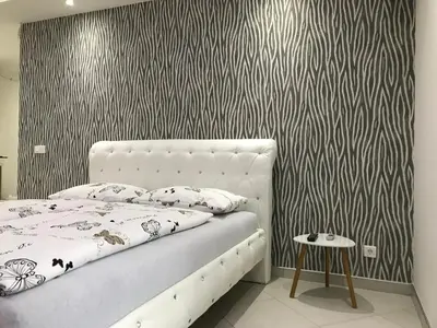 a bedroom with a bed and a black and white wall at Apartment Ajla in Tuzla