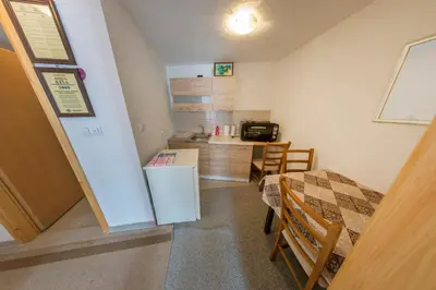 a small kitchen with a table and a refrigerator at Apartment Resaa in Bihać