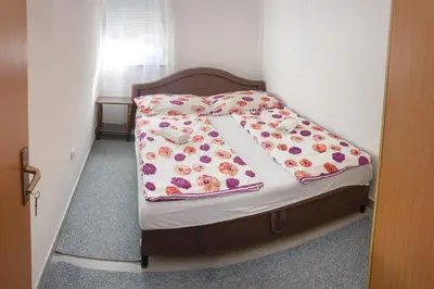 a small bed in a small room with a flower blanket at Apartment Resaa in Bihać