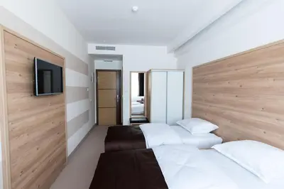 a bedroom with two beds and a flat screen tv at Hotel Novitas Livno in Livno