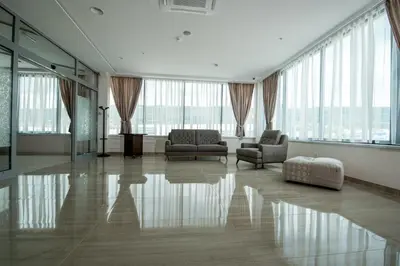a large living room with two chairs and windows at Hotel Novitas Livno in Livno