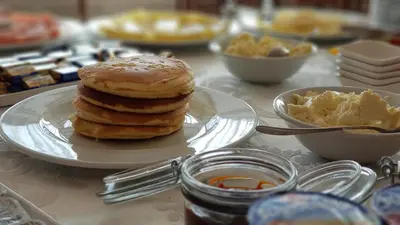 a stack of pancakes on a plate on a table at Hotel Novitas Livno in Livno