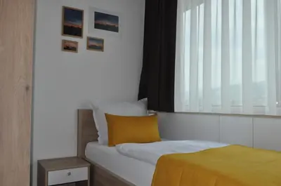 a small bedroom with a bed and a window at Hotel Novitas Livno in Livno