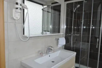 a bathroom with a sink and a mirror and a shower at Hotel Novitas Livno in Livno