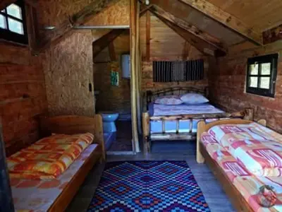 a room with two beds and a rug at Etno kuce Miljevic in Šipovo