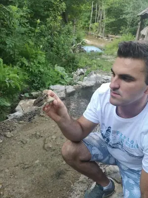 a man is holding a frog in his hand at Etno kuce Miljevic in Šipovo