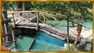 a bridge over a pool of blue water at Etno kuce Miljevic in Šipovo