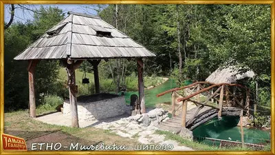 a wooden gazebo with a bridge and a pond at Etno kuce Miljevic in Šipovo