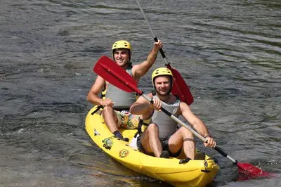 two men in a yellow kayak on the water at Etno kuce Miljevic in Šipovo