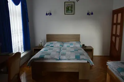 a bedroom with a bed with a blue and white quilt at Apartment Sarah in Bihać