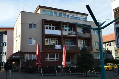 a building with red umbrellas in front of it at Apartment Sarah in Bihać