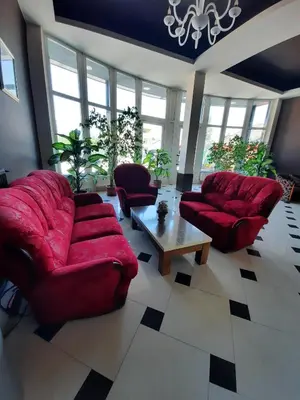 a living room with red couches and a coffee table at Motel Tiron in Kakanj