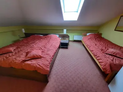 two beds in a small room with red sheets at Motel Tiron in Kakanj