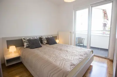 a bedroom with a large bed with a large window at Jelena Apartment in Doboj