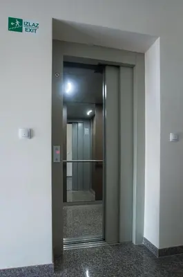 an elevator in a building with a glass door at Jelena Apartment in Doboj