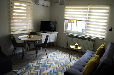 a living room with a couch and a table and a tv at Apartment Fortuna in Visoko