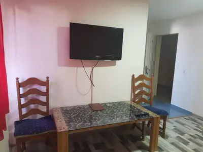 a table and chairs with a television on a wall at Guesthouse 