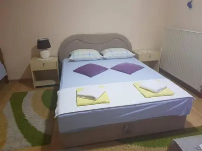 a bedroom with a bed with purple and yellow pillows at Guesthouse 