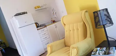 a yellow chair in a kitchen next to a refrigerator at Holidayhouse Visoko in Visoko