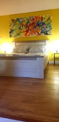 a bedroom with a bed with a painting on the wall at Holidayhouse Visoko in Visoko