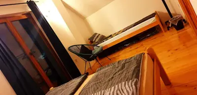 a living room with a wooden floor and a room with a fan at Holidayhouse Visoko in Visoko