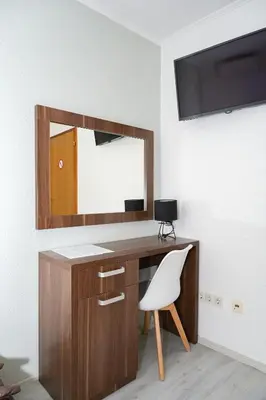 a desk with a mirror and a white chair at Motel Plaza in Jajce