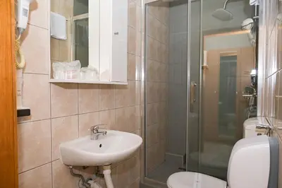a bathroom with a sink and a toilet and a shower at Motel Plaza in Jajce