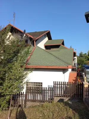 a house with a green roof and a fence at Apartments Emir in Tuzla