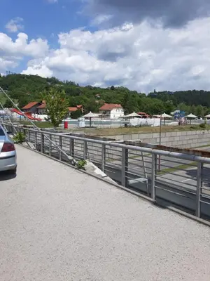 a car driving on a road next to a fence at Apartments Emir in Tuzla