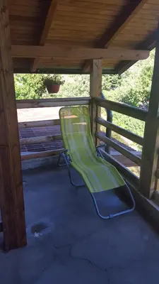 a green slide sitting under a porch with a fence at Apartment Sajra in Kulen Vakuf