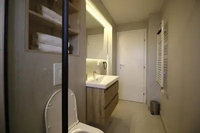 a bathroom with a white toilet and a sink at La Paloma Blanca in Tuzla