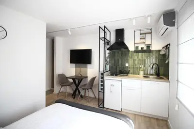 a small kitchen with white cabinets and a table at La Paloma Blanca in Tuzla